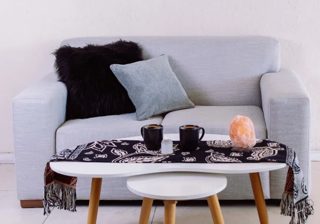 Sillón gris con almohadones y mesa living moderno